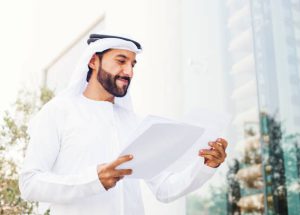 Middle eastern businessman in kandora looking at documents